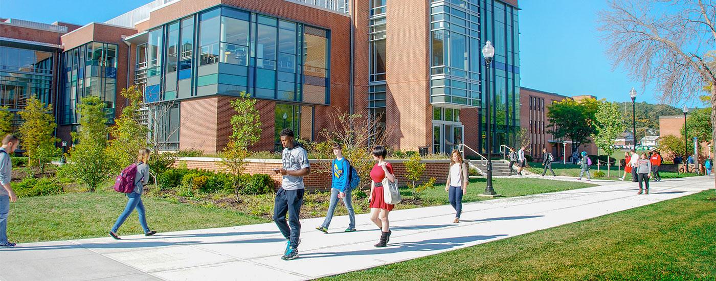 Students walk to class in front of the Gira Center for Communications Information and Technology on a bright, sunny day